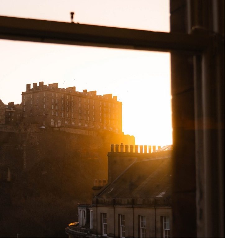 Edinburgh Castle at sunset seen through a hotel window